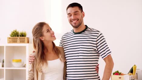 happy-couple-hugging-at-home-kitchen