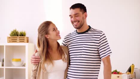 happy-couple-hugging-at-home-kitchen