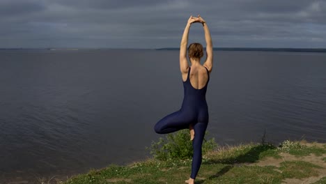 Mujer-de-yoga-en-ropa-deportiva-plantean-contra-lago