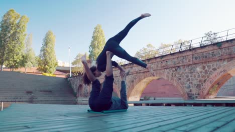 Schönes-paar-praktizieren-Acro-Yoga-am-Morgen