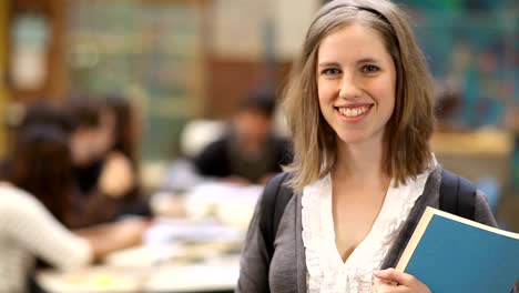 An-attractive-college-student-poses-for-the-camera-with-books-in-hand