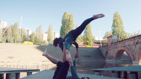 Schönes-paar-praktizieren-Acro-Yoga-am-Morgen