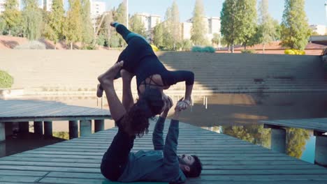 Hermosa-pareja-practicando-acro-yoga-en-la-mañana