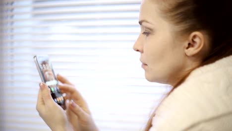 compras-en-línea,-una-mujer-joven,-viendo-los-productos-en-la-tienda-online-en-la-pantalla-del-smartphone