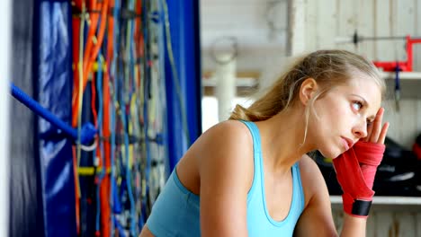 Female-boxer-relaxing-in-fitness-studio-4k