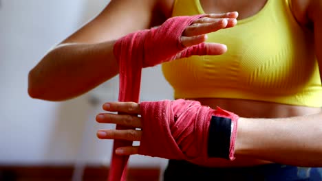 Female-boxer-wearing-hand-wrap-in-fitness-studio-4k