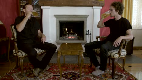 Two-men-drinking-beer-in-front-of-the-fireplace