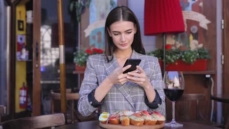 Schöne-Frau,-die-die-Nahrung-Fotos-auf-dem-Handy-im-Restaurant