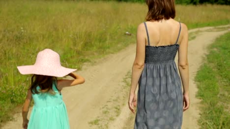 Mother-and-her-daughter-walking-along-a-rural-road