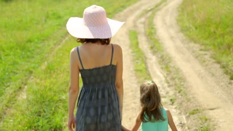 Mother-and-her-daughter-walking-along-a-rural-road