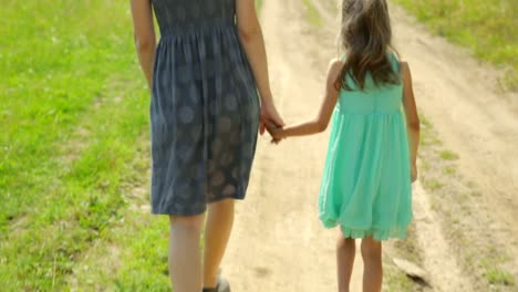 Mother-and-her-daughter-walking-along-a-rural-road