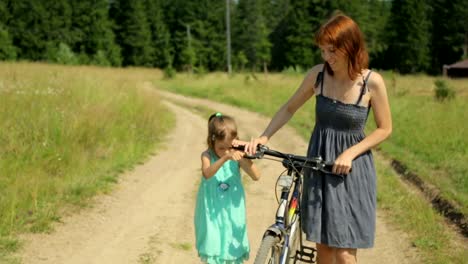 Mother-and-her-daughter-walking-along-a-rural-road