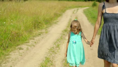 Mutter-und-Tochter-zu-Fuß-entlang-der-Landstraße