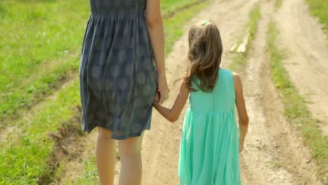 Mother-and-her-daughter-walking-along-a-rural-road