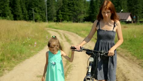 Mother-and-her-daughter-walking-along-a-rural-road