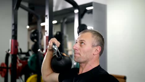 Close-up.-Handsome-guy-doing-exercise-with-a-kettlebell-in-the-gym-4K-Slow-Mo