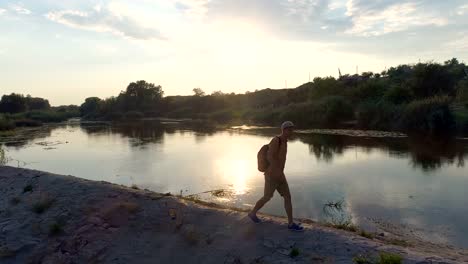 Young-man-walking-on-riverbank