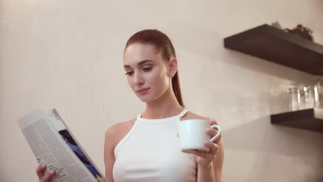 Mujer-con-periódico-de-beber-café-en-el-desayuno-en-la-cocina