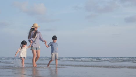 SLOW-MOTION,-madre-soltera-caminando-con-su-hijo-y-su-hija-en-la-playa-juntos.-Concepto-de-familia,-vacaciones-y-viajes.