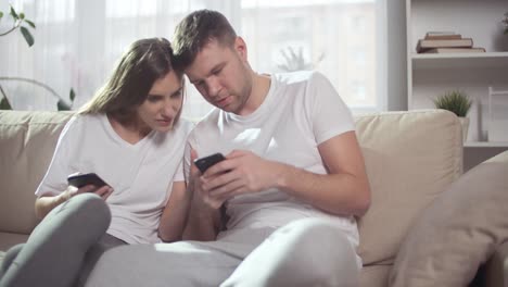 Young-Couple-Looking-at-Phones