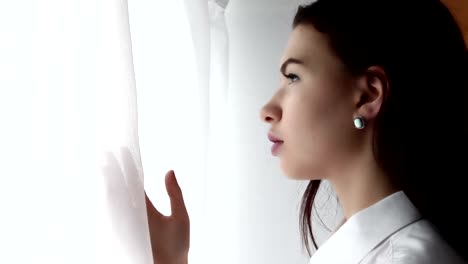 Young-woman-waiting-near-the-curtains