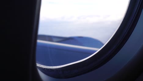 Flugzeug-Fenster-mit-Blick-auf-die-Wolken-vom-Beifahrersitz