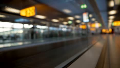 Passenger-with-suitcase-moving-on-escalator-at-the-airport,-terminal-hall