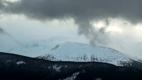 Zeit-Ablauf-Gewitterwolken-über-Winter-Gebirge-dunklen-Kiefern-Wald-Vordergrund-Naturlandschaft-bewegen