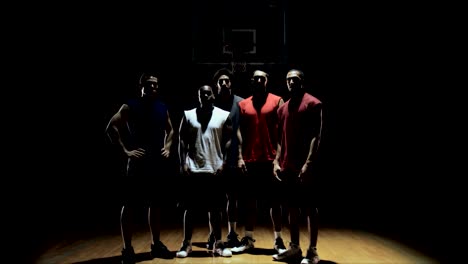 Group-of-basketball-players,-posing-on-the-court.