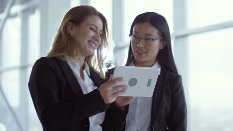 Cheerful-Businesswoman-Looking-at-Tablet