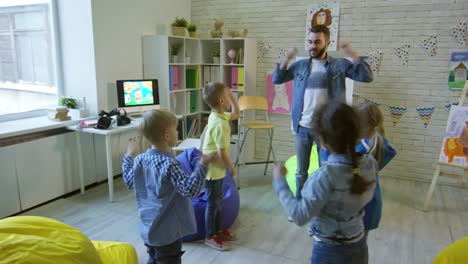 Mann,-wärmende-Übungen-mit-Kindern-im-Kindergarten