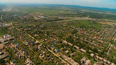 Helicóptero-(abejón,-quadcopter)-vuela-sobre-un-establecimiento,-árboles-y-campos