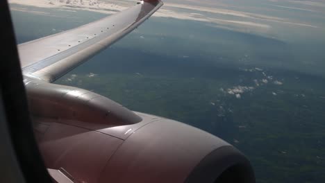 Motor-de-avión-en-vuelo-vista-a-través-de-una-ventana-de-avión-viendo-nubes-para-viajar-alrededor-del-mundo