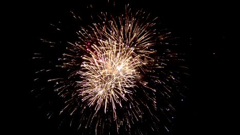 Ein-wunderschönen-dunklen-Himmel-wird-durch-Blinken-der-festlichen-Feuerwerk-beleuchtet.-Eine-reiche-purpurrote-Farbe-ist-über-den-ganzen-Himmel-sichtbar.-Funken-in-einer-nebligen-Wolke-aus-leuchtend-rote-Farbe