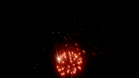 Festive-fireworks.-Bright-and-saturated-colors-against-the-background-of-the-dark-sky.-A-beautiful-fireworks-of-two-lights.-Yellow-and-crimson-sparks-are-visible-in-the-night-sky