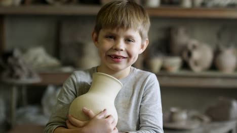 Boy-Posing-with-Ceramic-Vase-in-Pottery-Workshop