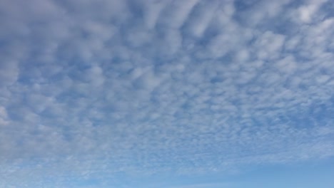 Cloudy-sky.-White-clouds-disappear-in-the-hot-sun-on-blue-sky.-Time-lapse-motion-clouds-blue-sky-background.-Blue-sky-with-white-clouds-and-sun.