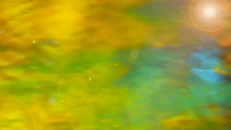 Closeup-Plätschern-des-Wasser-mit-grüner-und-gelber-Farbe-und-Aufflackern-des-Lichts.