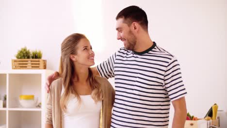 happy-couple-hugging-at-home-kitchen