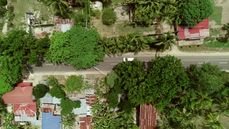 Aerial-view-following-car-on-road-in-Batuan,-Philippines.