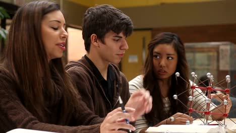 College-students-study-course-material-in-a-group-at-a-table-filled-with-books