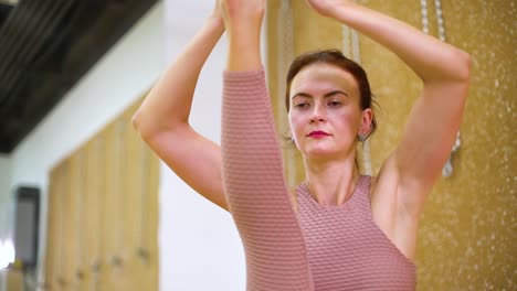 Mujer-joven-que-se-extiende-en-el-estudio-de-yoga