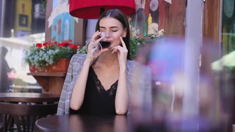 Hermosa-mujer-bebiendo-vino-de-vidrio-restaurante