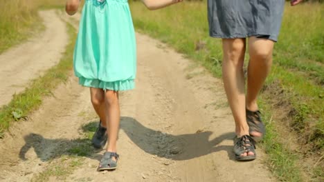 Mutter-und-Tochter-zu-Fuß-entlang-der-Landstraße