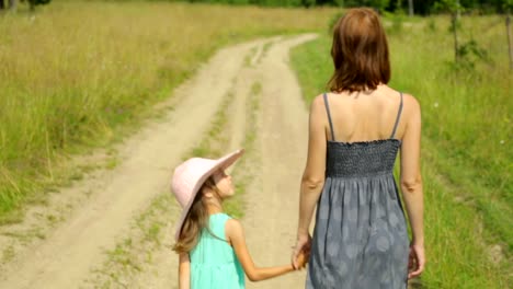 Mother-and-her-daughter-walking-along-a-rural-road