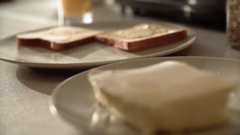 Toast-mit-Butter.-Hände,-die-Anwendung-von-Butter-auf-Brot-Closeup