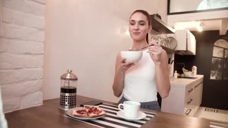 Mujer-desayunando-en-casa,-disfrutando-de-comida-de-mañana