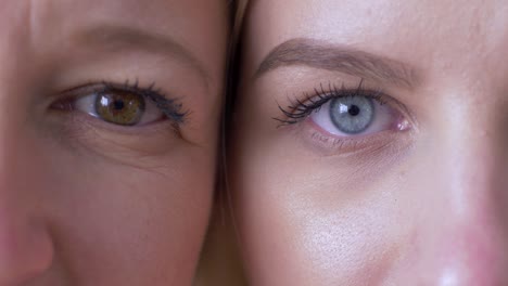 Generationsunterschied,-Augen-von-Mama-und-Tochter-nebeneinander-und-schauen-gemeinsam-auf-die-Kamera