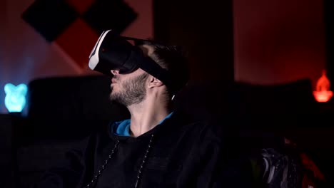 Male-gamer-enjoying-virtual-reality-wearing-VR-glasses,-making-gestures-with-his-hand