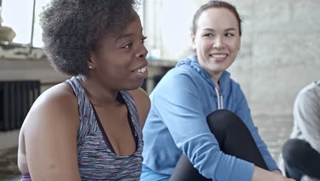 Frau-im-Gespräch-mit-Freundinnen-in-der-Fitness-Klasse